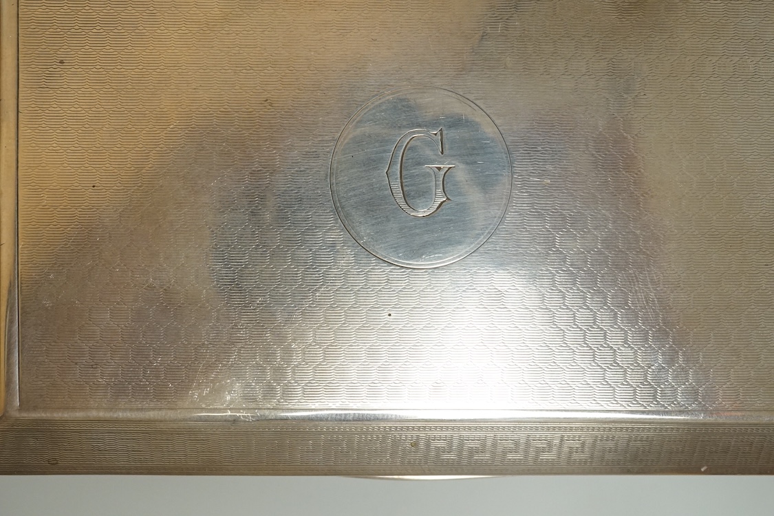 An engine turned silver rectangular cigarette box, 14.1cm and two mid 20th century engine turned silver cigarette cases.